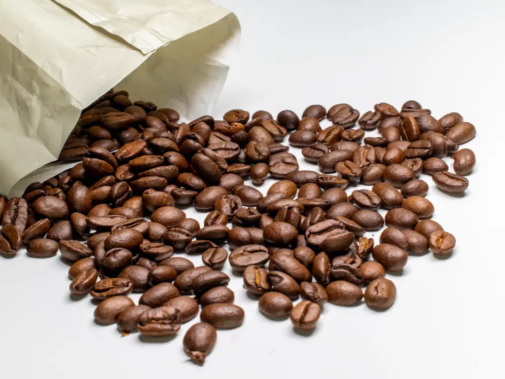 closeup paper bag with roasted coffee beans lights isolated white background